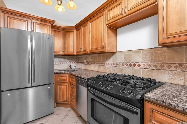 kitchen featuring stainless steel appliances, tasteful backsplash, and dark stone counters