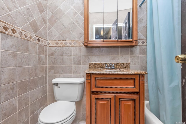 full bathroom featuring vanity, shower / bath combination with curtain, tile walls, and toilet