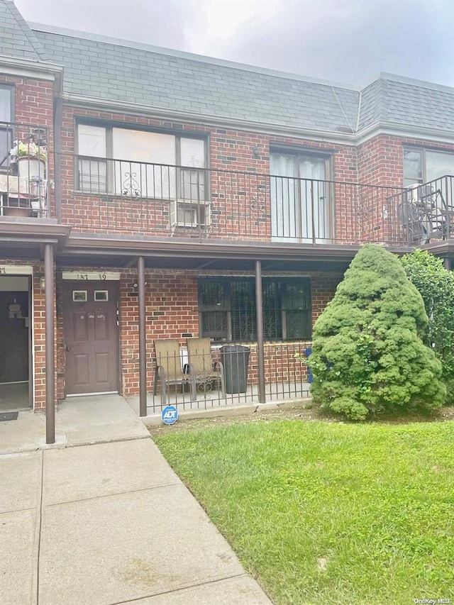 exterior space with a balcony and a lawn