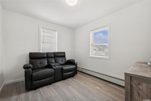 sitting room with light hardwood / wood-style floors and a baseboard heating unit