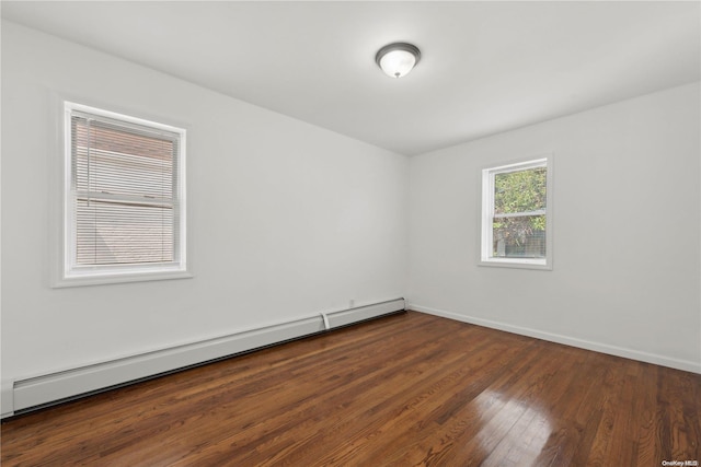 unfurnished room featuring dark wood-type flooring and a baseboard radiator