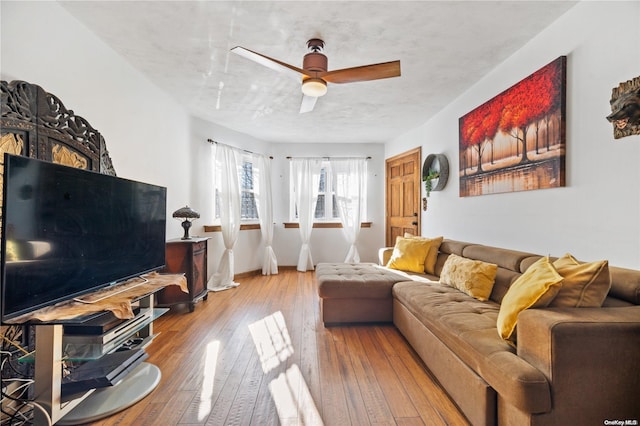 living room with wood-type flooring, a textured ceiling, and ceiling fan