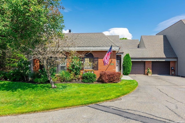 view of front of home with a front lawn and a garage