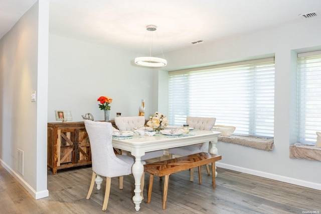 dining space with hardwood / wood-style flooring and a healthy amount of sunlight