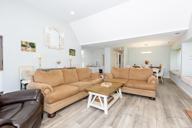 living room featuring light hardwood / wood-style flooring and lofted ceiling