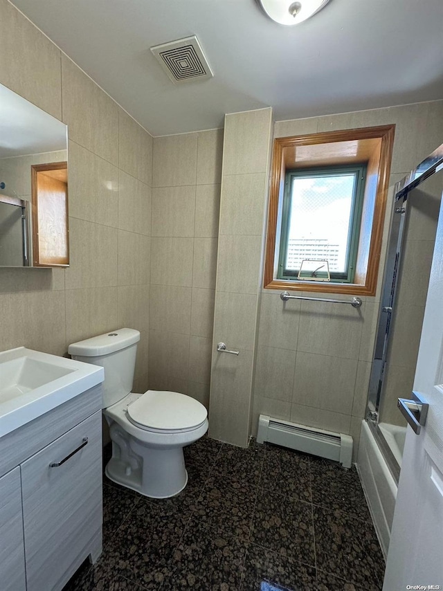 full bathroom with combined bath / shower with glass door, vanity, baseboard heating, tile walls, and toilet