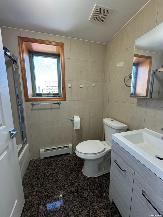 full bathroom featuring vanity, baseboard heating, and tile walls