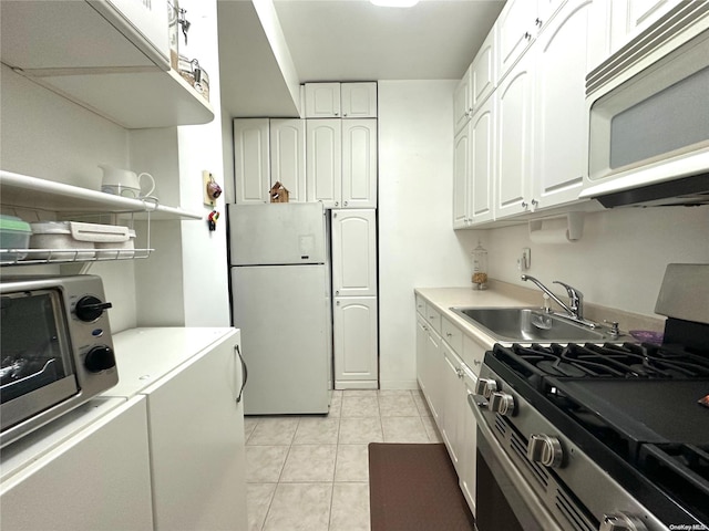 kitchen with sink, white cabinets, light tile patterned flooring, and appliances with stainless steel finishes