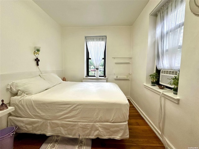 bedroom featuring multiple windows and dark wood-type flooring