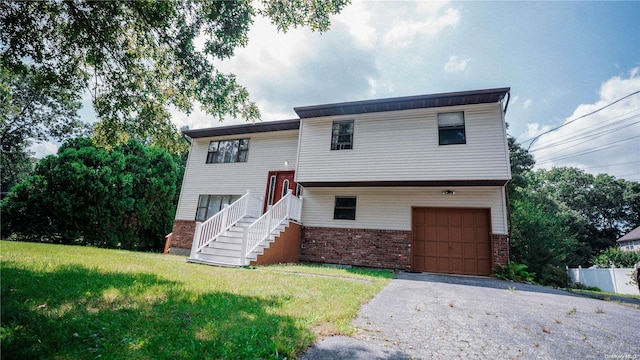 split foyer home featuring a garage and a front yard