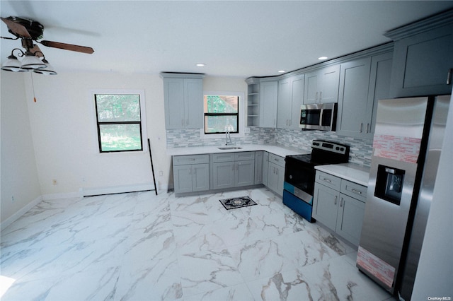 kitchen with appliances with stainless steel finishes, tasteful backsplash, gray cabinetry, ceiling fan, and sink