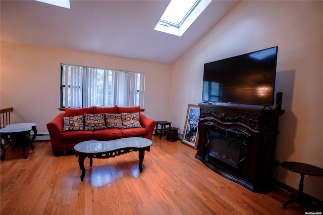 living room featuring hardwood / wood-style floors, baseboard heating, high vaulted ceiling, and a skylight