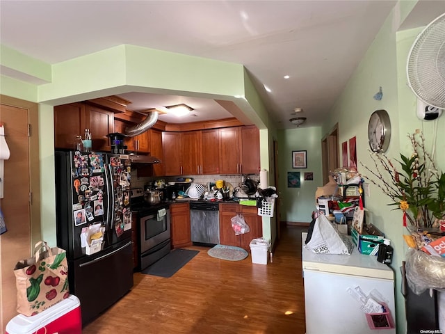 kitchen with appliances with stainless steel finishes, tasteful backsplash, and dark wood-type flooring