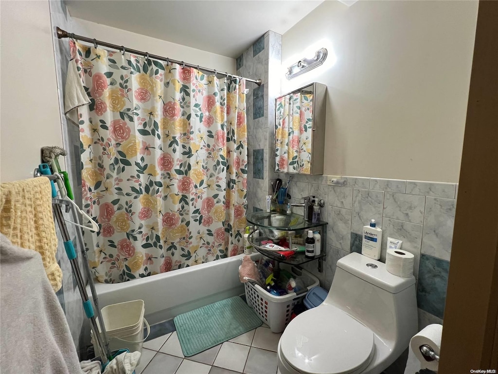 bathroom with tile patterned floors, toilet, tile walls, and shower / tub combo