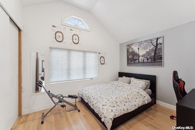 bedroom with hardwood / wood-style floors and lofted ceiling