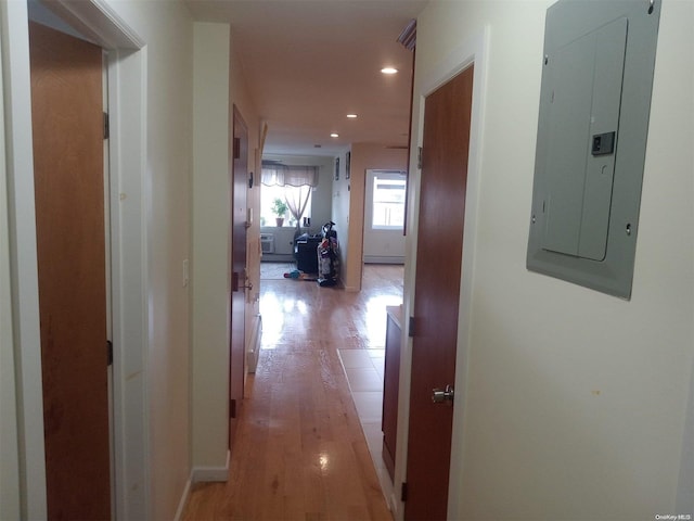 corridor with light hardwood / wood-style floors and electric panel