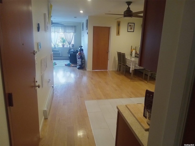 hallway with baseboard heating and light hardwood / wood-style flooring