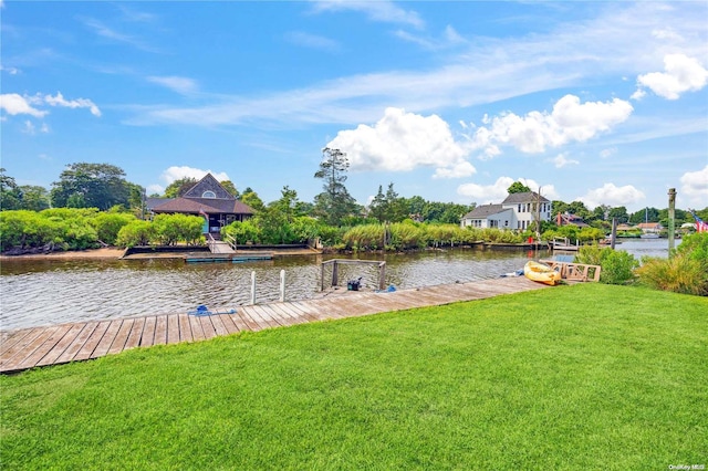 view of dock featuring a lawn and a water view