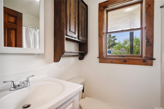 bathroom with vanity, a shower with shower curtain, and toilet