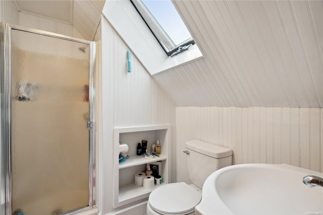 bathroom featuring toilet, lofted ceiling with skylight, a shower with shower door, and wooden walls