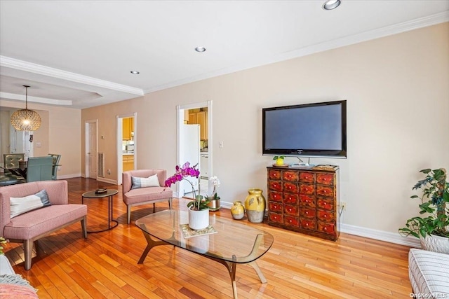 living room featuring a chandelier, light hardwood / wood-style flooring, and ornamental molding