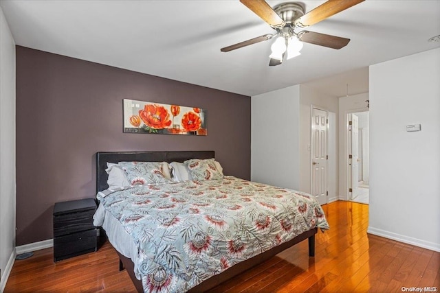 bedroom with hardwood / wood-style floors, a closet, and ceiling fan