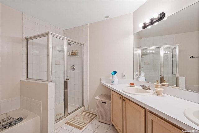 bathroom featuring tile patterned flooring, shower with separate bathtub, and vanity