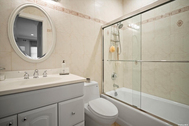 full bathroom with vanity, enclosed tub / shower combo, tile walls, and toilet