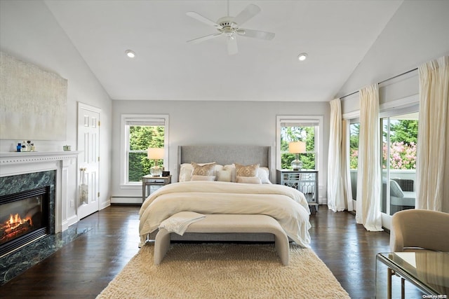 bedroom with ceiling fan, dark hardwood / wood-style floors, a premium fireplace, and multiple windows