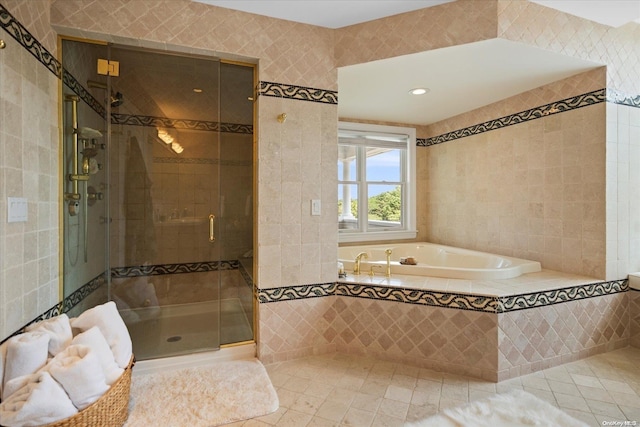 bathroom with tile patterned flooring, tile walls, and independent shower and bath