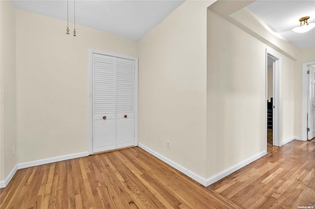 unfurnished bedroom with a closet and hardwood / wood-style flooring