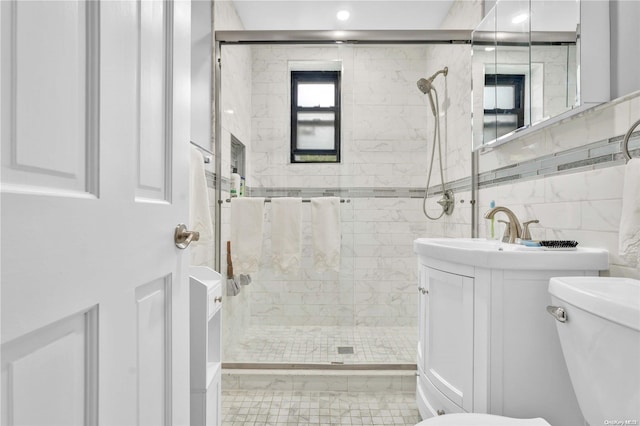 bathroom with vanity, toilet, and a tile shower