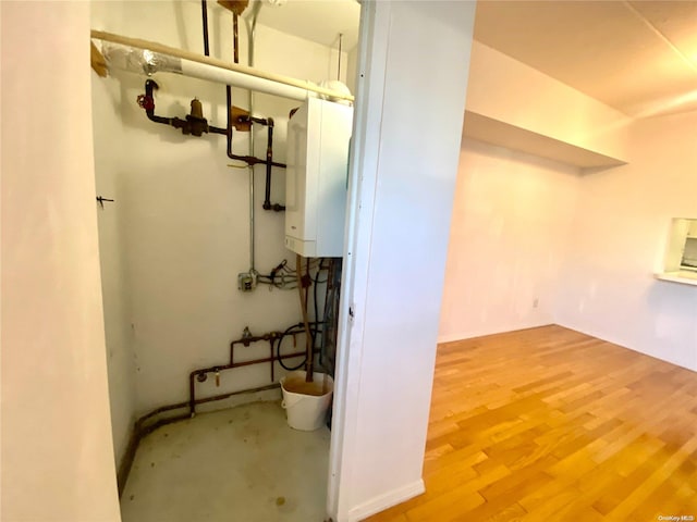 basement with hardwood / wood-style floors and tankless water heater