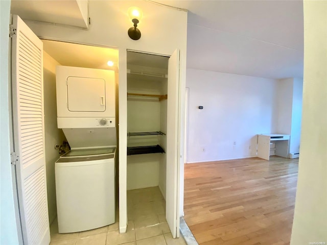 washroom featuring light hardwood / wood-style floors and stacked washer and clothes dryer