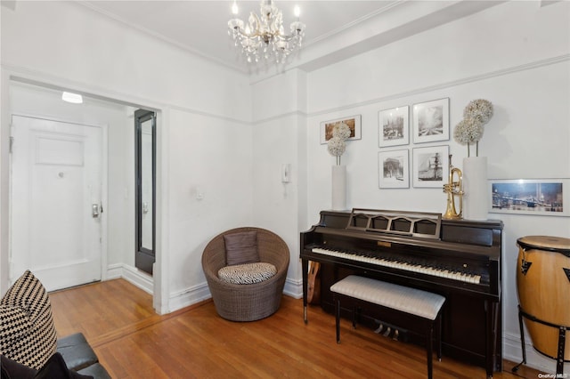 miscellaneous room with crown molding, an inviting chandelier, and hardwood / wood-style flooring