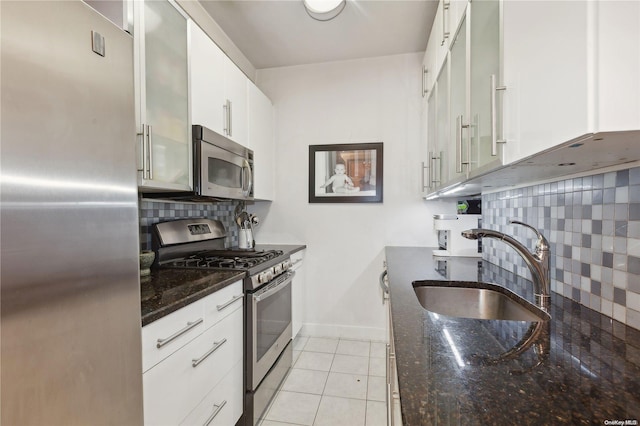 kitchen featuring white cabinetry, sink, backsplash, light tile patterned flooring, and appliances with stainless steel finishes