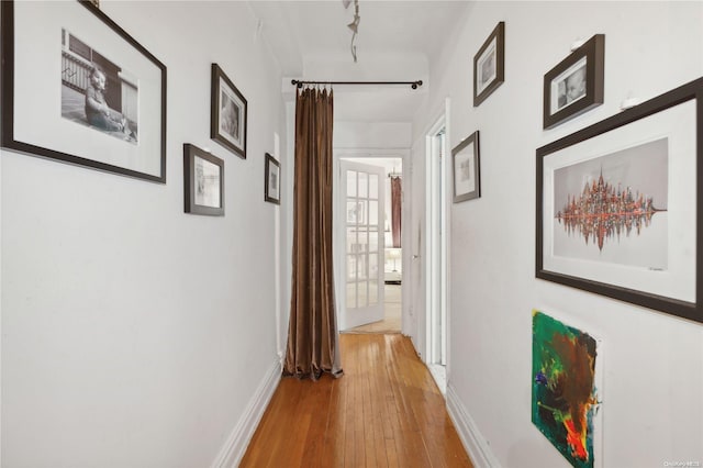 corridor featuring light hardwood / wood-style flooring and rail lighting