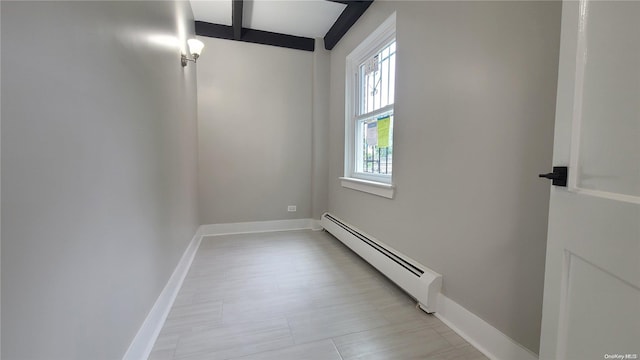 spare room with baseboard heating and beam ceiling