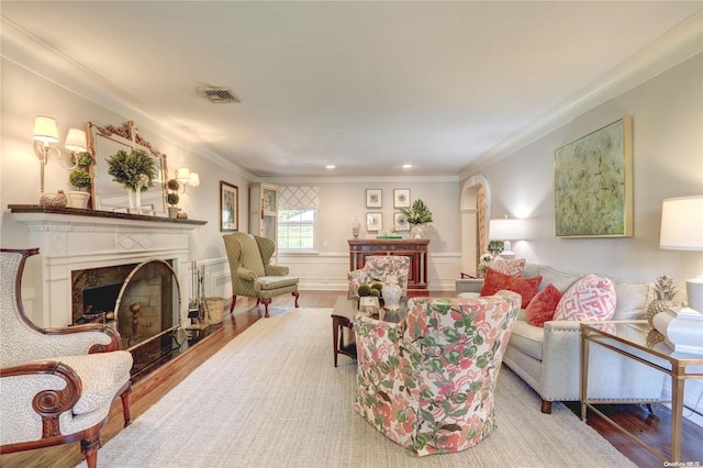 living room with hardwood / wood-style floors, crown molding, and a premium fireplace