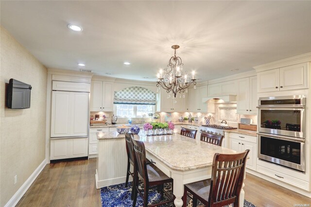 122 Roxen Rd, Rockville Centre, NY 11570 - dining room with dark wood-type flooring, a chandelier, recessed lighting, and baseboards