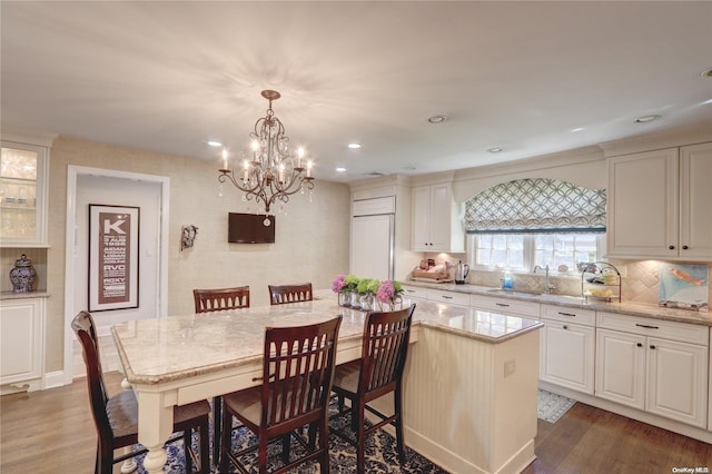 122 Roxen Rd, Rockville Centre, NY 11570 - kitchen with wood finished floors, a chandelier, light stone counters, tasteful backsplash, and recessed lighting