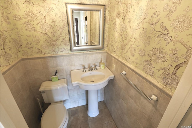 bathroom featuring tile patterned flooring, tile walls, and toilet