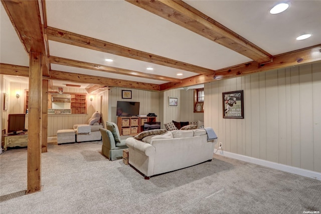 carpeted living room with beamed ceiling and wood walls