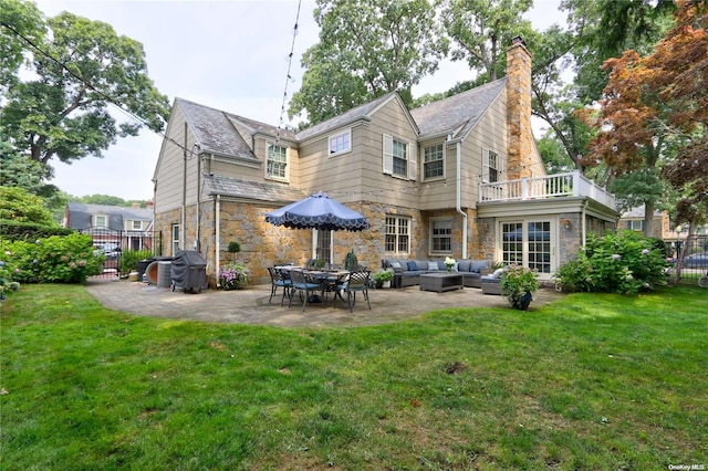 rear view of property with a lawn, a balcony, an outdoor hangout area, and a patio