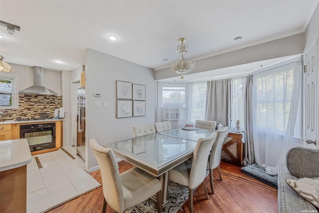 dining room featuring an inviting chandelier, ornamental molding, and light hardwood / wood-style flooring