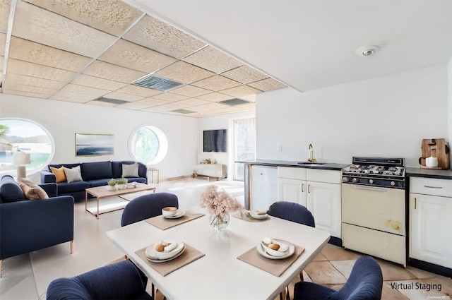 tiled dining space featuring a drop ceiling and sink