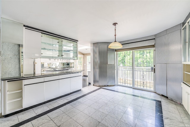 kitchen featuring white cabinetry and hanging light fixtures