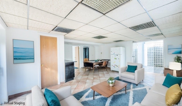 tiled living room with a paneled ceiling