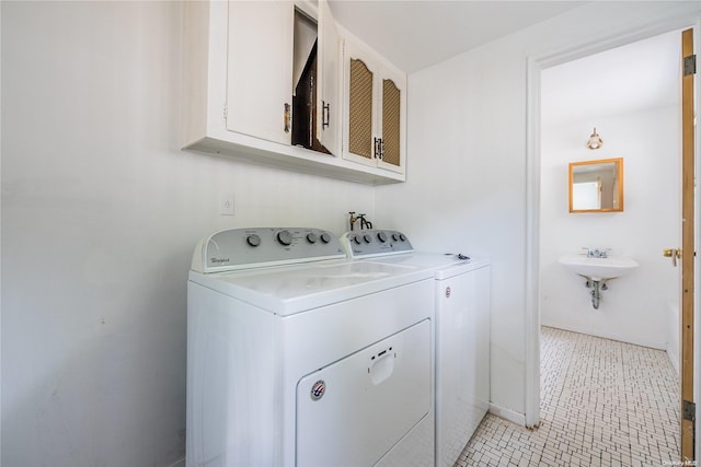 laundry area with washing machine and dryer and cabinets