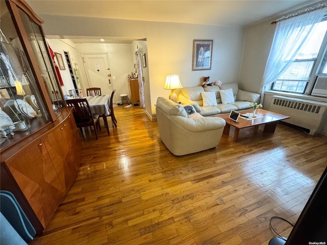 living room featuring radiator heating unit and light hardwood / wood-style flooring